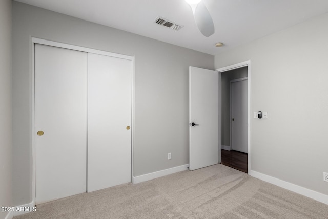 unfurnished bedroom with carpet floors, a closet, baseboards, and a ceiling fan
