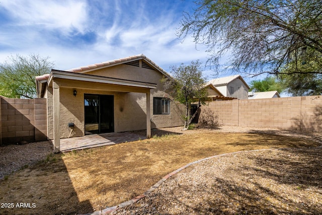back of house featuring a fenced backyard, stucco siding, and a patio area