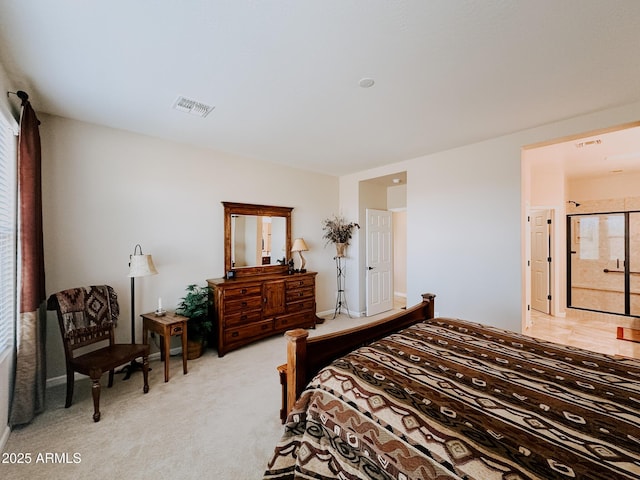 bedroom with ensuite bathroom and light colored carpet