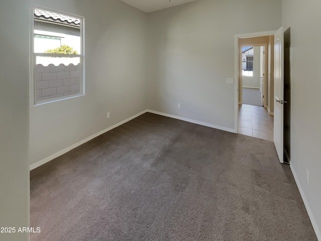 unfurnished room with dark carpet