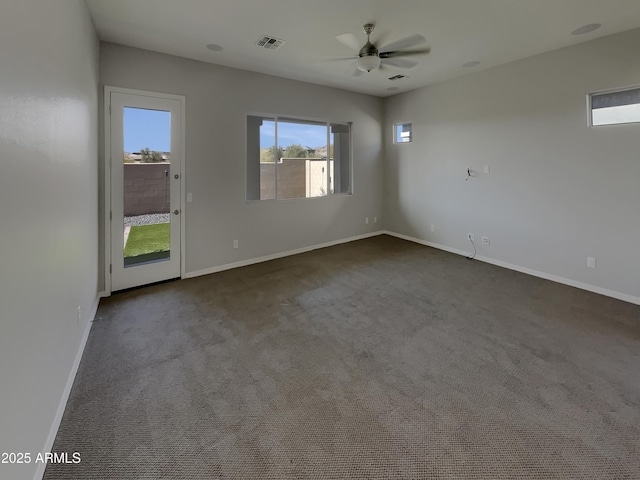 spare room with ceiling fan and dark colored carpet