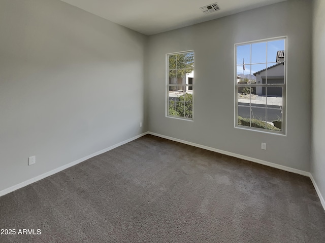 unfurnished room featuring dark carpet