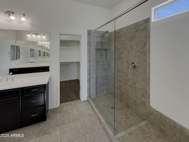 bathroom with vanity, tiled shower, and tile patterned floors