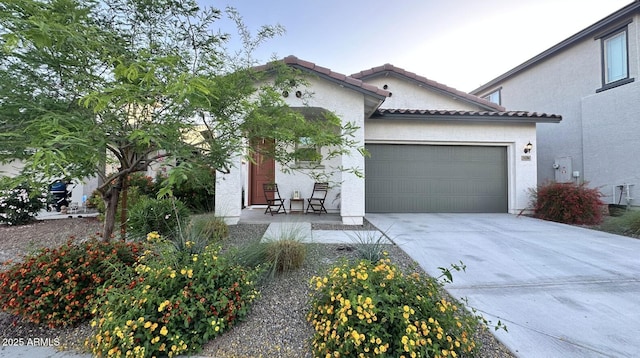mediterranean / spanish house with stucco siding, a tile roof, an attached garage, and concrete driveway