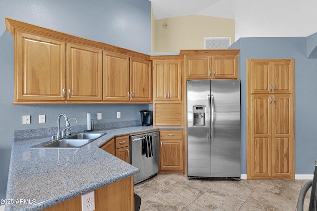 kitchen featuring light tile patterned floors, sink, stainless steel appliances, and light stone counters