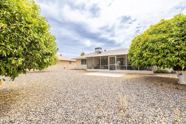 rear view of property featuring a patio, a sunroom, and central AC unit