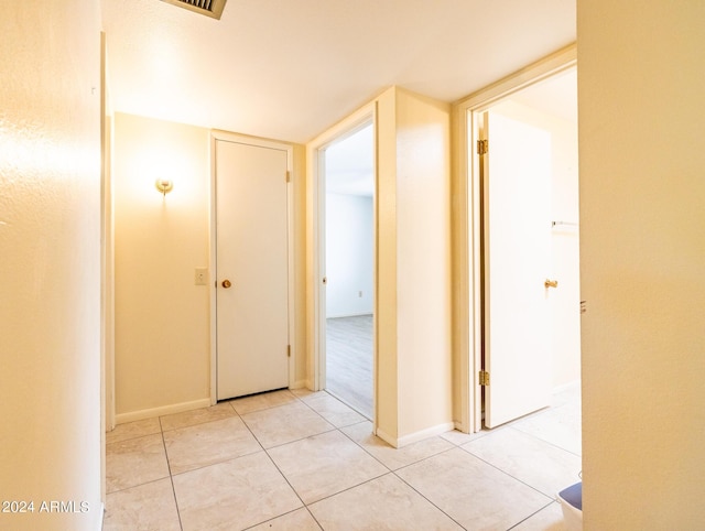 hall with light tile patterned floors and baseboards