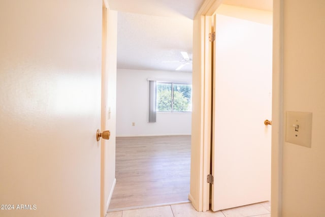 hallway with light wood-type flooring and baseboards