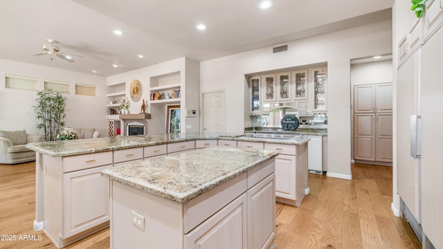 kitchen with recessed lighting, a ceiling fan, light wood-type flooring, a kitchen island, and open floor plan