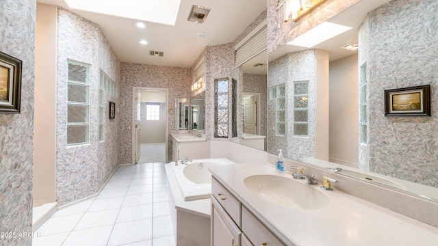 full bathroom featuring a garden tub, a sink, wallpapered walls, tile patterned floors, and visible vents