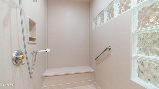 full bathroom with walk in shower and baseboards