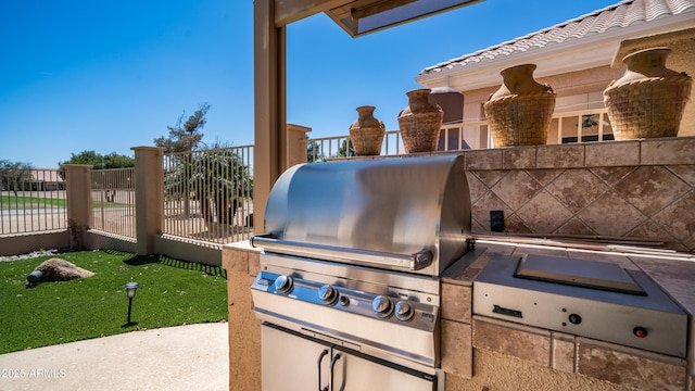 view of patio / terrace featuring fence, area for grilling, and exterior kitchen