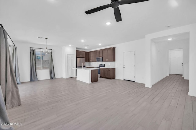 unfurnished living room with recessed lighting, a sink, light wood finished floors, and ceiling fan with notable chandelier