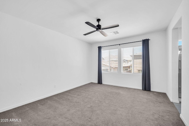 spare room with baseboards, carpet, a ceiling fan, and visible vents