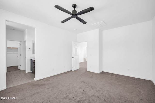 unfurnished bedroom with baseboards, carpet, ensuite bath, and visible vents