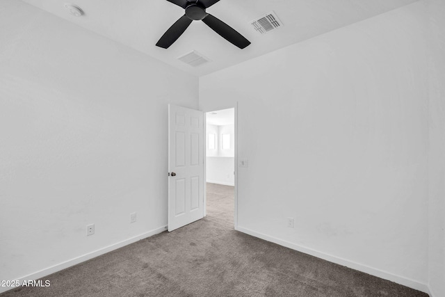 empty room featuring carpet floors, baseboards, a ceiling fan, and visible vents