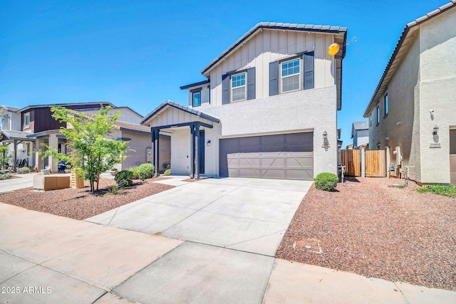 traditional home with board and batten siding, a gate, fence, concrete driveway, and an attached garage