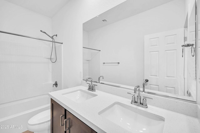 bathroom featuring a sink, washtub / shower combination, toilet, and double vanity
