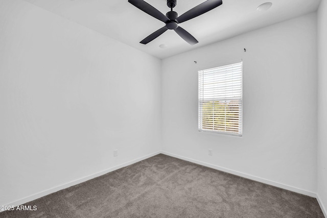 carpeted empty room with baseboards and a ceiling fan
