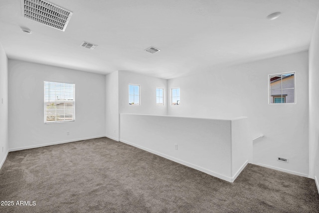 unfurnished room with carpet floors, baseboards, and visible vents