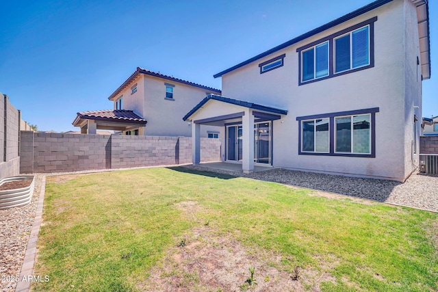 rear view of property with a yard, central AC unit, a fenced backyard, and stucco siding