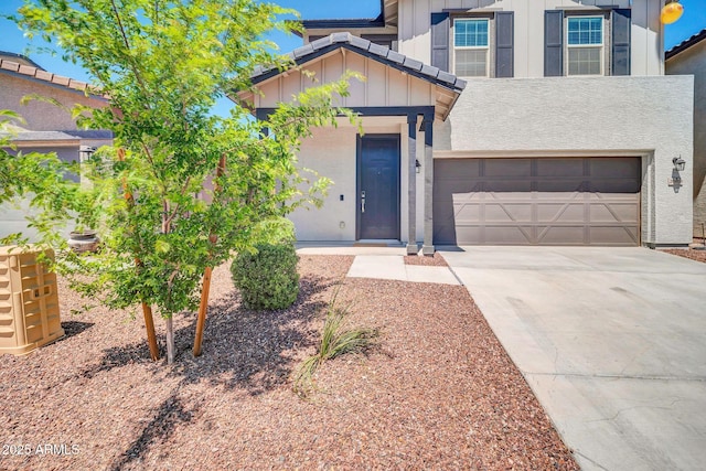traditional-style home with a garage, board and batten siding, driveway, and stucco siding