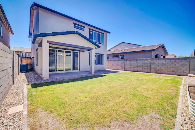 back of property featuring a lawn, a fenced backyard, stucco siding, and a patio