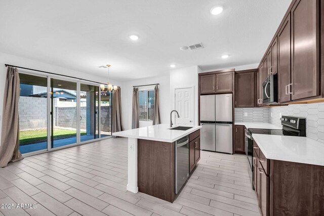 kitchen with light countertops, a sink, dark brown cabinetry, and stainless steel appliances
