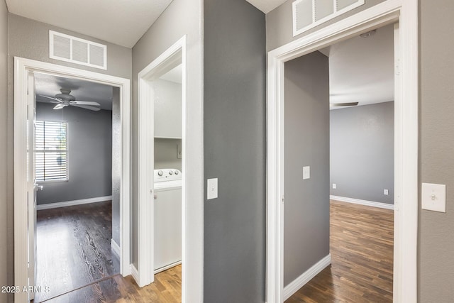 hallway with washer / dryer and dark hardwood / wood-style floors