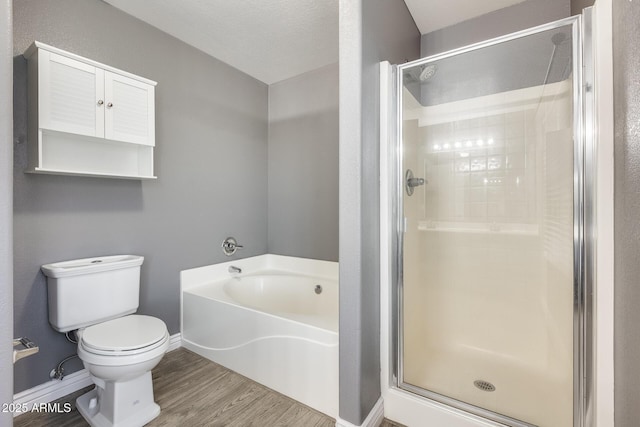 bathroom with hardwood / wood-style floors, plus walk in shower, and toilet