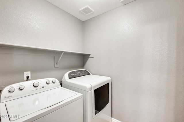 clothes washing area featuring separate washer and dryer