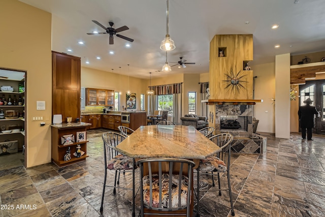 dining room with ceiling fan and a tiled fireplace