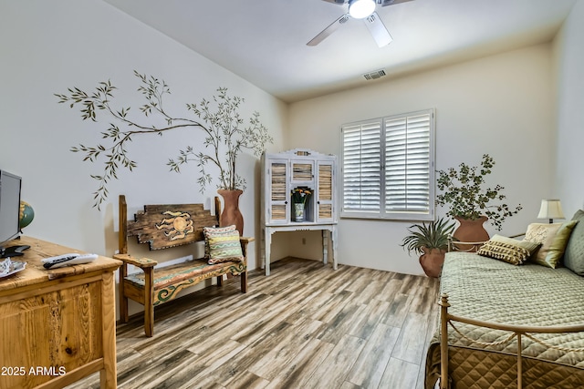 living area featuring hardwood / wood-style floors and ceiling fan