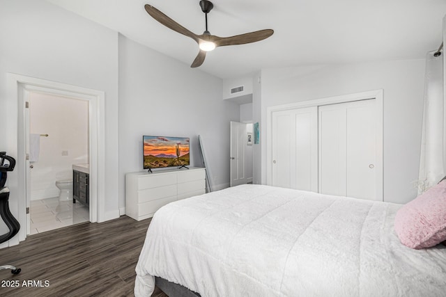 bedroom with a closet, wood finished floors, baseboards, connected bathroom, and lofted ceiling