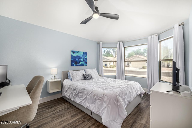 bedroom featuring baseboards, dark wood finished floors, a ceiling fan, and a desk