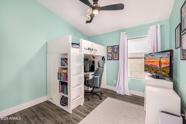 bedroom with wood finished floors, baseboards, an office area, vaulted ceiling, and a ceiling fan
