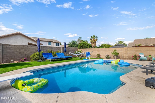 view of pool featuring a fenced backyard, a diving board, and a patio