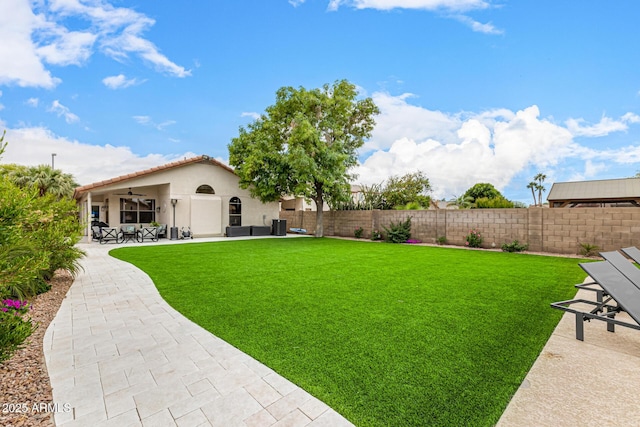 view of yard featuring ceiling fan and a patio