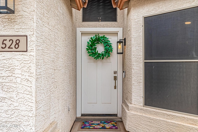 entrance to property featuring stucco siding