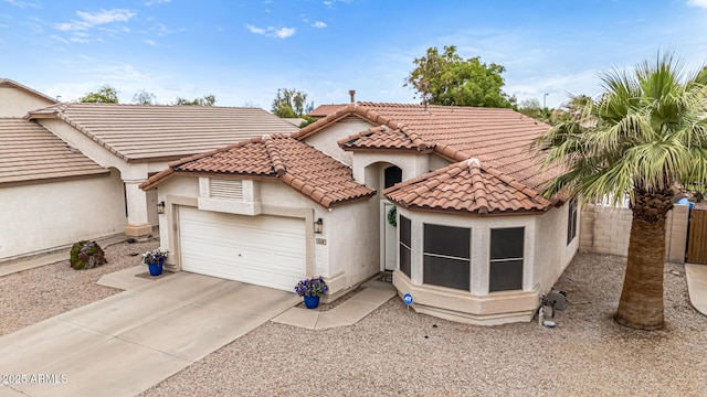 mediterranean / spanish-style home featuring stucco siding, an attached garage, concrete driveway, and a tile roof
