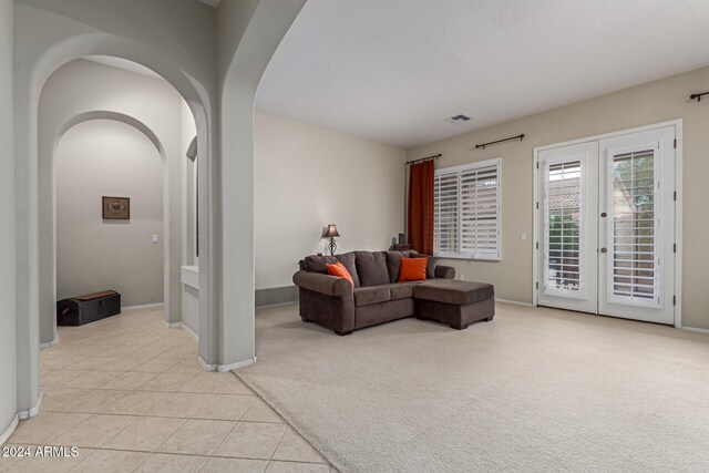 living room featuring french doors and light tile patterned flooring