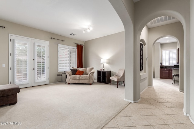 sitting room with french doors and light colored carpet