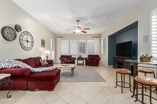 living room featuring ceiling fan, a wealth of natural light, and light tile patterned floors