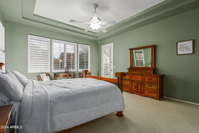 bedroom with ceiling fan, a raised ceiling, and carpet floors