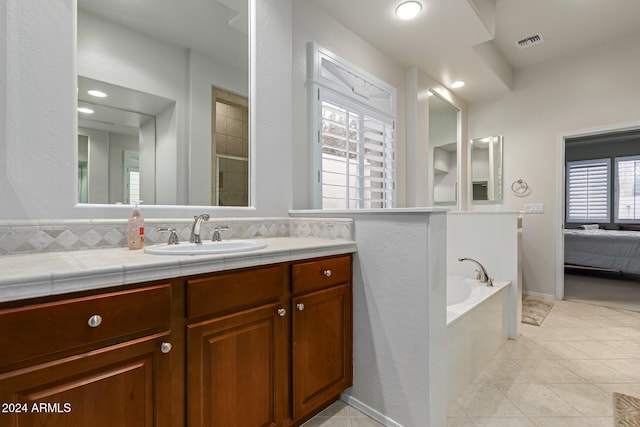 bathroom with vanity, shower with separate bathtub, tile patterned floors, and a wealth of natural light