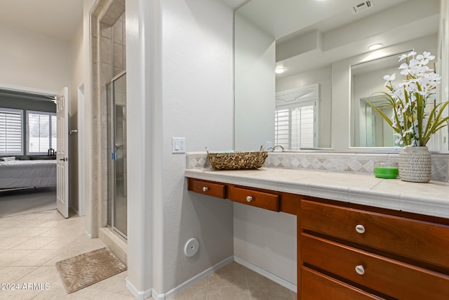 bathroom with vanity, decorative backsplash, tile patterned floors, and a shower with door