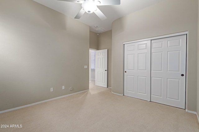 unfurnished bedroom featuring a closet, ceiling fan, and light colored carpet