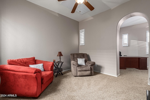 living area featuring vaulted ceiling, carpet flooring, and ceiling fan