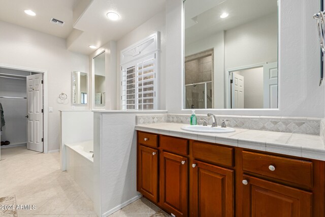 bathroom with vanity, separate shower and tub, and tile patterned flooring