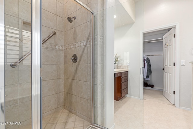 bathroom featuring vanity, walk in shower, and tile patterned flooring